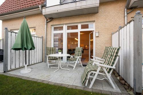 a patio with chairs and a table and an umbrella at Villa Olga Wohnung 3 in Grömitz