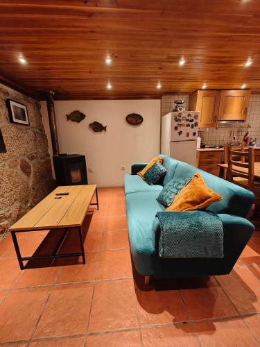 a living room with a blue couch and a wooden table at Casa Moreirinha in Guarda