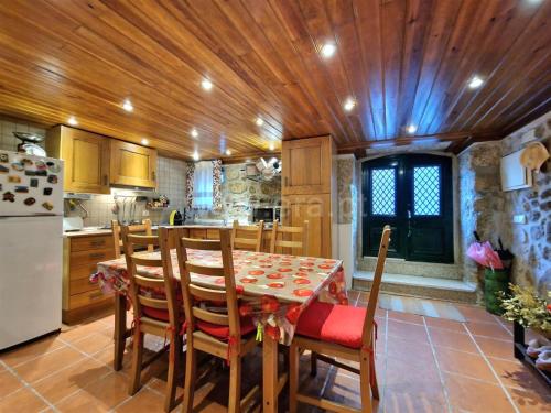 a kitchen with a table with chairs and a refrigerator at Casa Moreirinha in Guarda