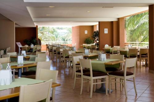 アブサルアにあるAQI Pegasos Clubのテーブルと椅子が並ぶダイニングルーム