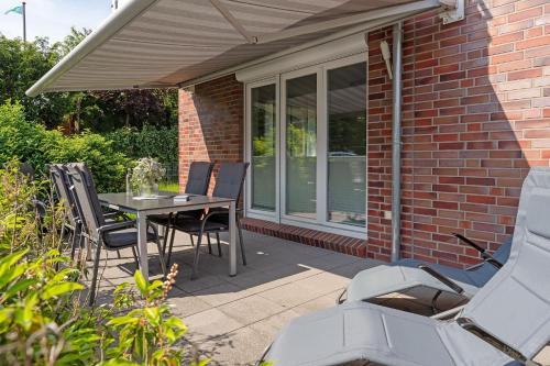 a patio with a table and chairs in front of a brick house at Brenkenhagener Weg 8-10 Wohnung 1 in Körnick
