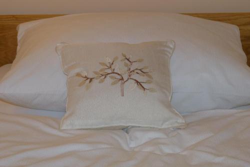 a pillow with a tree on it on a bed at Guest House Eco Vila Mila in Rogaška Slatina