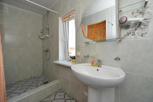 ein Bad mit einem Waschbecken und einer Dusche in der Unterkunft Rambyno apartamentai in Klaipėda