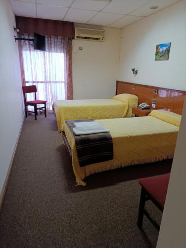 a hotel room with two beds and a chair at Hotel Menfis in San Francisco