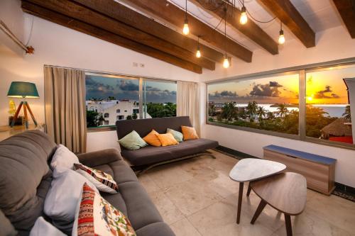 a living room with a couch and two large windows at CASCADAS,stylish family villa poolside steps from beach in Cancún