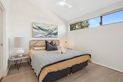 パースにあるTranquil Tree Views 2 Bedroom 2 Bathroom Apartmentのベッドと窓のある寝室