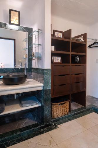 a bathroom with a sink and a mirror at CASCADAS,stylish family villa poolside steps from beach in Cancún