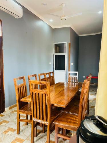 a dining room with a wooden table and chairs at KDP LODGE Kihonda in Morogoro