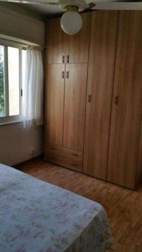 a bedroom with a bed and wooden cabinets and a window at Casetta Glicine in Ischia Town