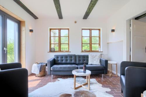 Una sala de estar con un sofá azul y una mesa. en Landhaus Auszeit, en Rüting