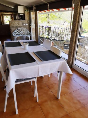 a table with chairs and a white table cloth on it at Casa do Loureiro in Paradela