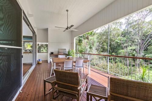a dining room with a table and chairs on a balcony at The Pavilions at Pearl in Pearl Beach