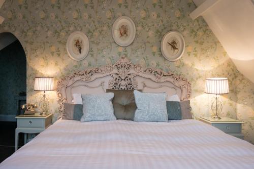 a bedroom with a large bed with two lamps at Maenan Abbey Hotel in Llanrwst