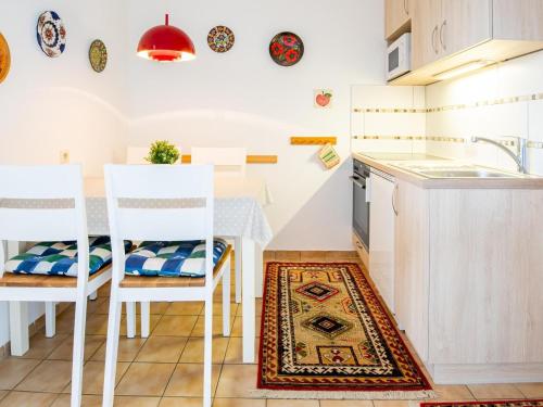 eine Küche mit einem Tisch, 2 Stühlen und einem Waschbecken in der Unterkunft Haus Meeresblick Wohnung 24 in Kellenhusen