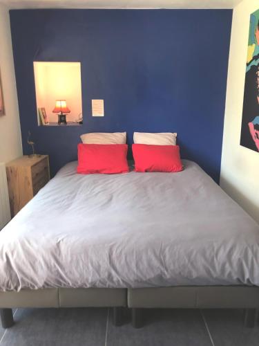 une chambre avec un lit avec deux oreillers rouges dans l'établissement Maison arty au charme unique - Proche Mail François Mitterrand, à Rennes