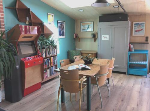 une salle à manger avec une table et un jeu vidéo dans l'établissement Maison arty au charme unique - Proche Mail François Mitterrand, à Rennes