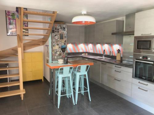 - une cuisine avec un comptoir et quelques tabourets dans l'établissement Maison arty au charme unique - Proche Mail François Mitterrand, à Rennes