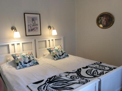 a white bed with two pillows on top of it at Kullabygdens Bed & Breakfast Höganäs in Jonstorp