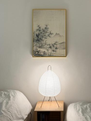 a lamp sitting on a table next to two beds at Ahn-sik, 安息 in Seoul