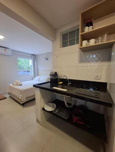 a kitchen and living room with a bed in a room at Condomínio Pickler in Juquei