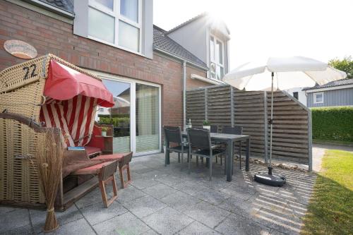 a patio with an umbrella and a table and chairs at Ferienhaus Salomons Sonne in Kellenhusen