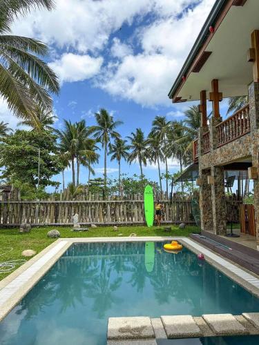a swimming pool in front of a house with palm trees at Tabularasa - T Palawan in San Vicente