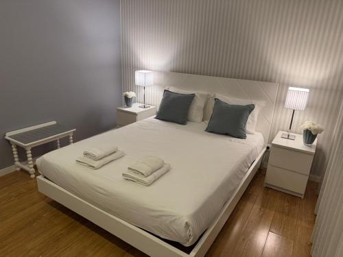 een slaapkamer met een groot wit bed en 2 nachtkastjes bij MyHome Braga1 in Braga