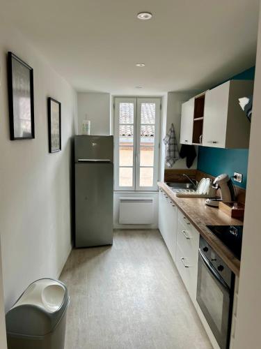 Elle comprend une petite cuisine avec un réfrigérateur et une fenêtre. dans l'établissement La dolce vita, à Albi