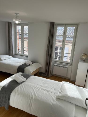 une chambre avec deux lits et deux fenêtres dans l'établissement La dolce vita, à Albi