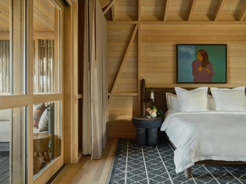 a bedroom with a white bed and a staircase at Kona Village A Rosewood Resort in Kailua-Kona