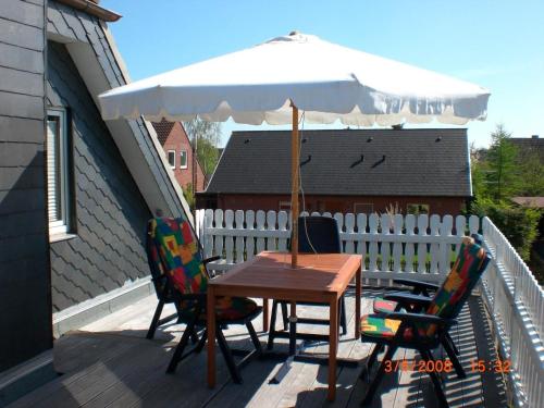 une table et des chaises avec un parasol sur une terrasse dans l'établissement Dornieden, à Fehmarn