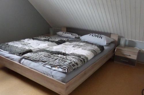 un lit avec des draps blancs et des oreillers dans une chambre dans l'établissement Dornieden, à Fehmarn