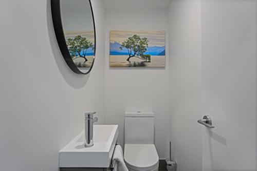 a bathroom with a sink and two pictures on the wall at Alpine Grandview Luxury Townhouse - Explore Wanaka in Albert Town
