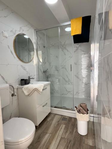a white bathroom with a shower and a toilet at Apartments by the sea Potocnica, Pag - 222 in Novalja
