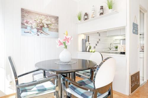 a dining room table with chairs and a vase of flowers at Panoramic NiNis Mupfel in Hansaland