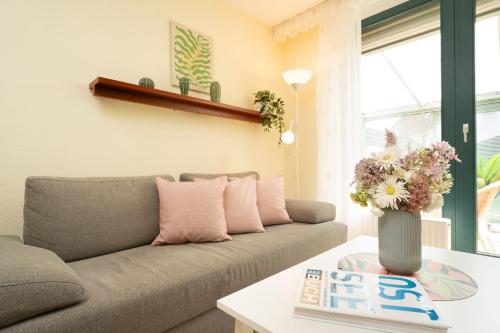 a living room with a couch and a vase with flowers at Lange Wiese 16b in Dahme