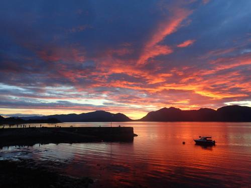 a sunset over a body of water with a boat at Holly Tree Hotel, Swimming Pool & Hot Tub in Glencoe