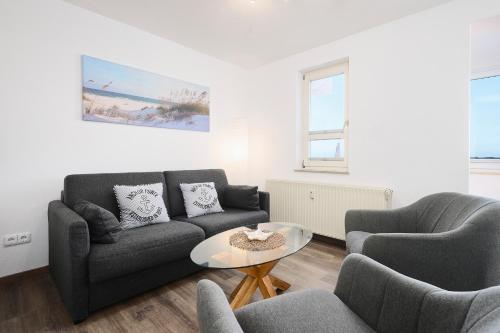 a living room with two couches and a table at Promenade 27 Koje 23 in Stakendorfer Strand