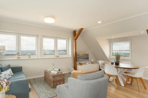 a living room with a couch and a table at Am Strande 31 Nixe in Neustadt in Holstein