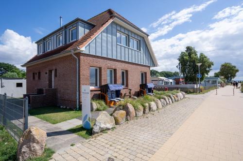 a small brick house on a brick road at Am Strande 31 Nixe in Neustadt in Holstein