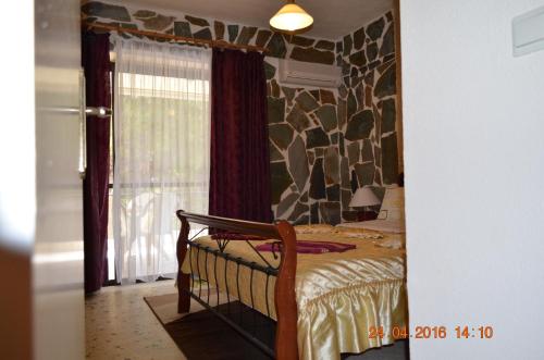 a bedroom with a bed with a rock wall at Apartments Zoumperi in Nea Makri