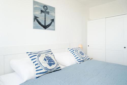 a bedroom with a bed with blue and white pillows at Haus Meeresblick Ankerplatz 84 in Kellenhusen
