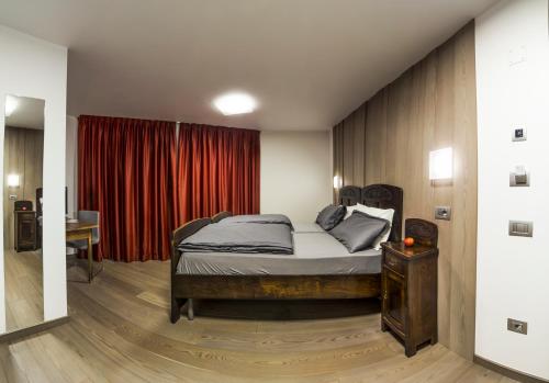 1 dormitorio con cama y cortina roja en NonSoloMele en Romallo