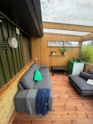 a patio with a couch on a wooden deck at Cozy House in Oxie Malmö in Oxie