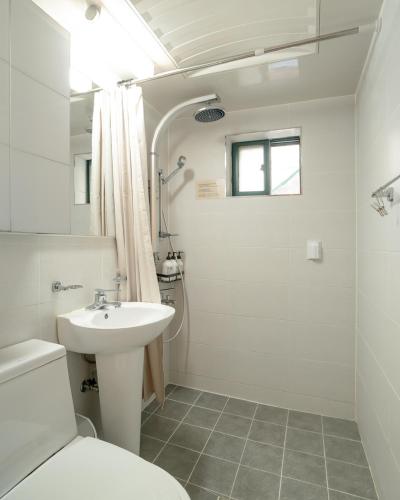 a white bathroom with a sink and a toilet at Ahn-sik, 安息 in Seoul