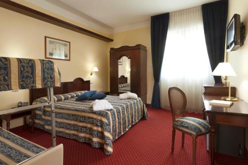 A bed or beds in a room at Hotel Milano Helvetia - in centro con piscina