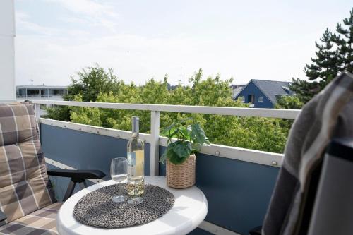 a bottle of wine sitting on a table on a balcony at Strandhotel Scharbeutz Kleine Krabbe in Scharbeutz