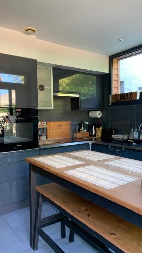 une grande cuisine avec une table en bois. dans l'établissement Superbe T3- Two bedrooms appartment with garden and pétanque! Perfect Spot!, à Bordeaux