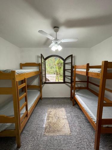 una habitación con tres literas y una ventana en Recanto Dom José, en Peruíbe