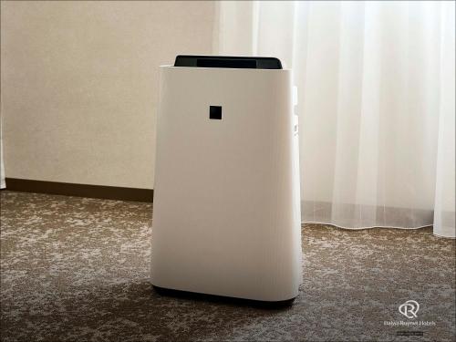 a white refrigerator sitting on the floor next to a curtain at Daiwa Roynet Hotel Morioka in Morioka